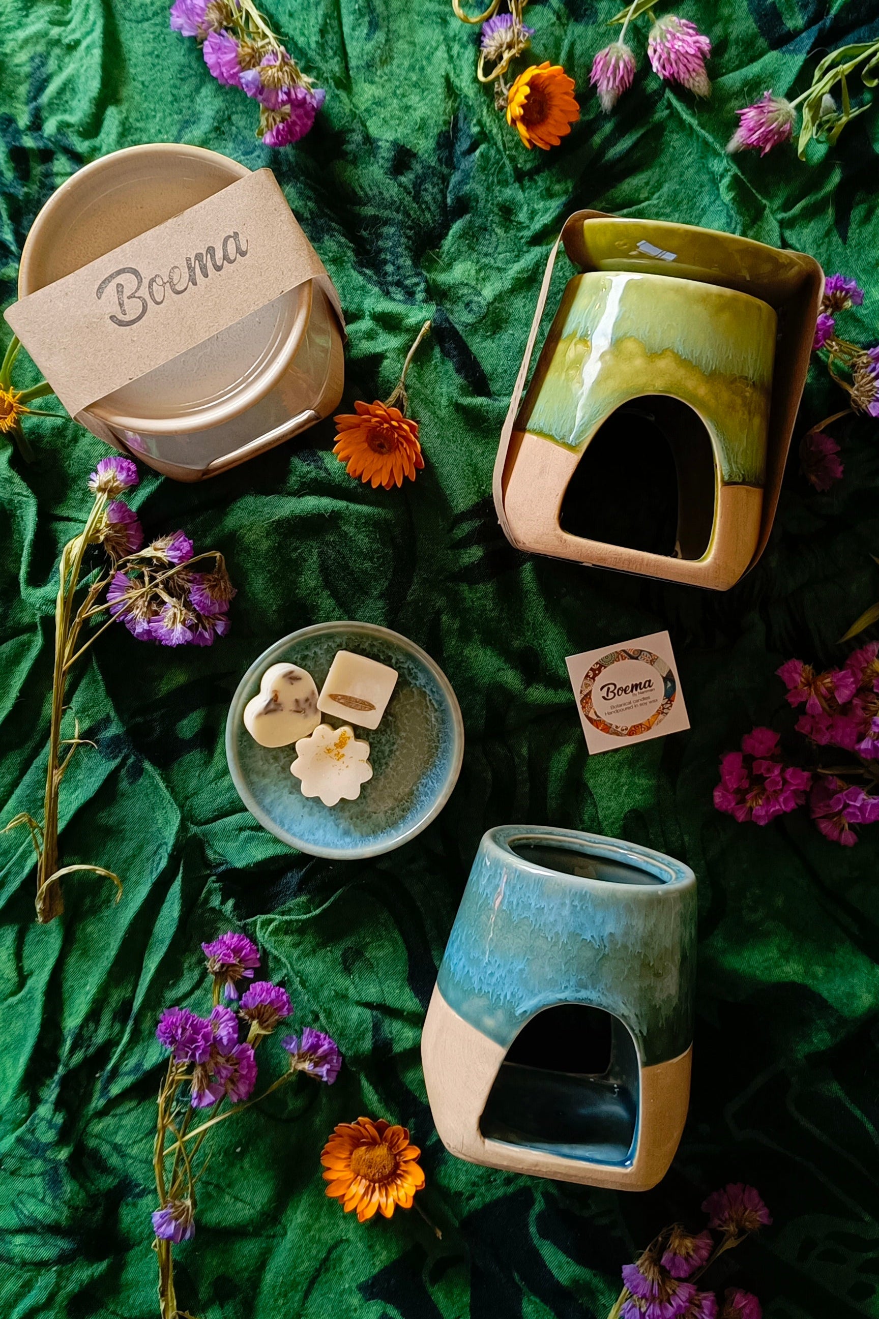 Ceramic burner with 'Boema' branding on a green leafy background with flowers and soy melts