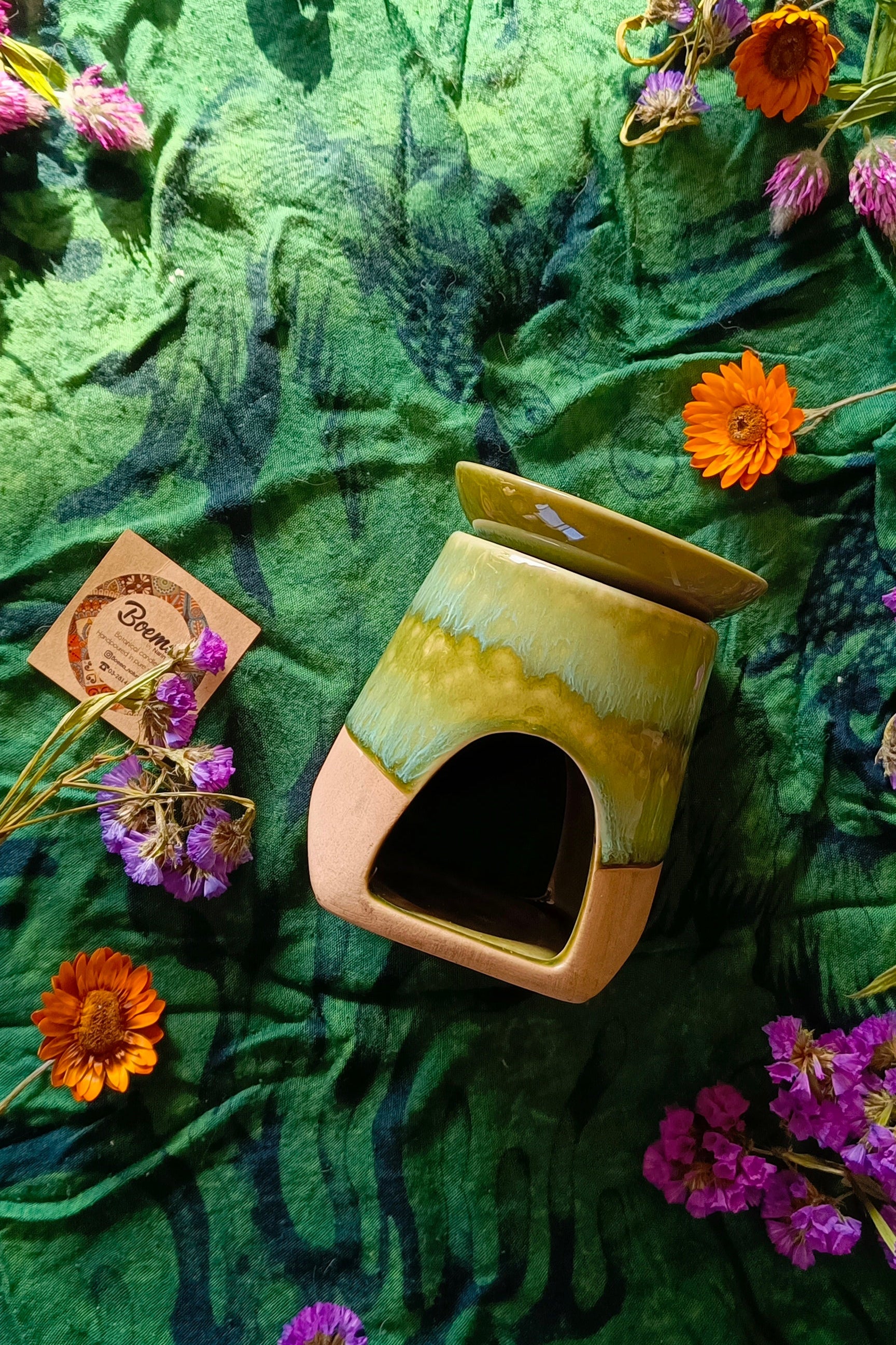 Ceramic diffuser with flowers on a green fabric background