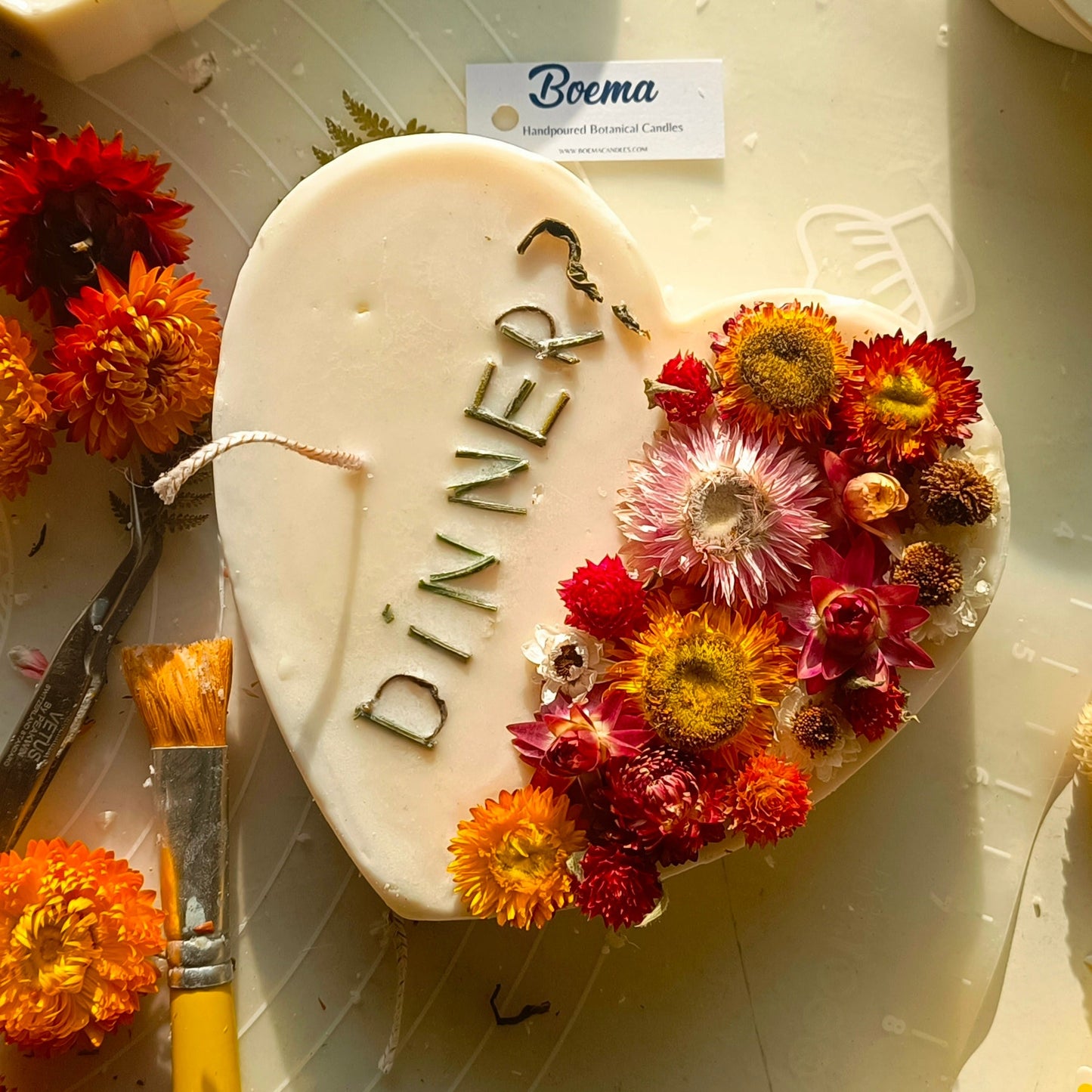 Heart-shaped candle with 'DINNER' invitation  designed with dried flowers